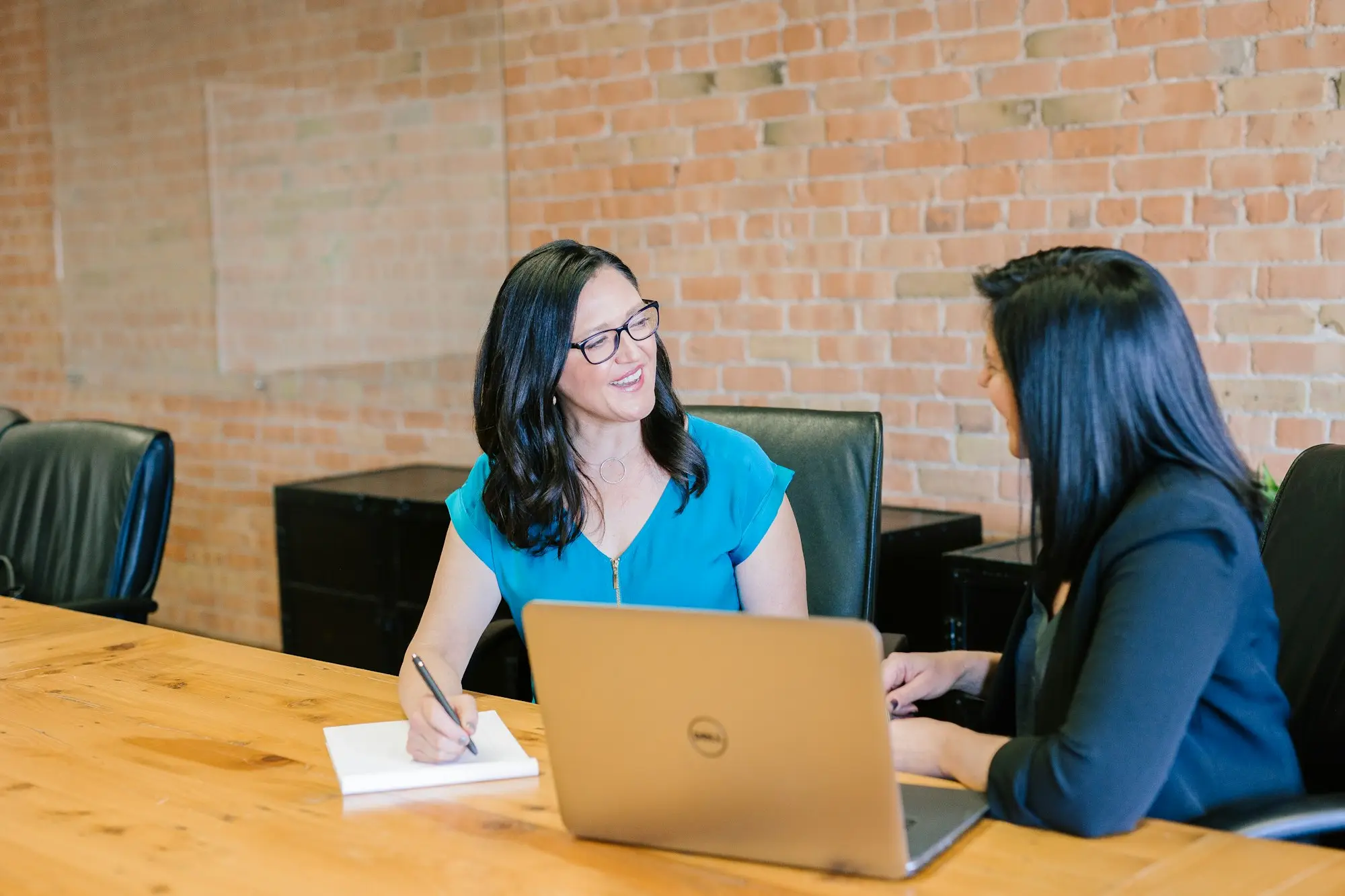 Two women in a meeting at a table with a laptop